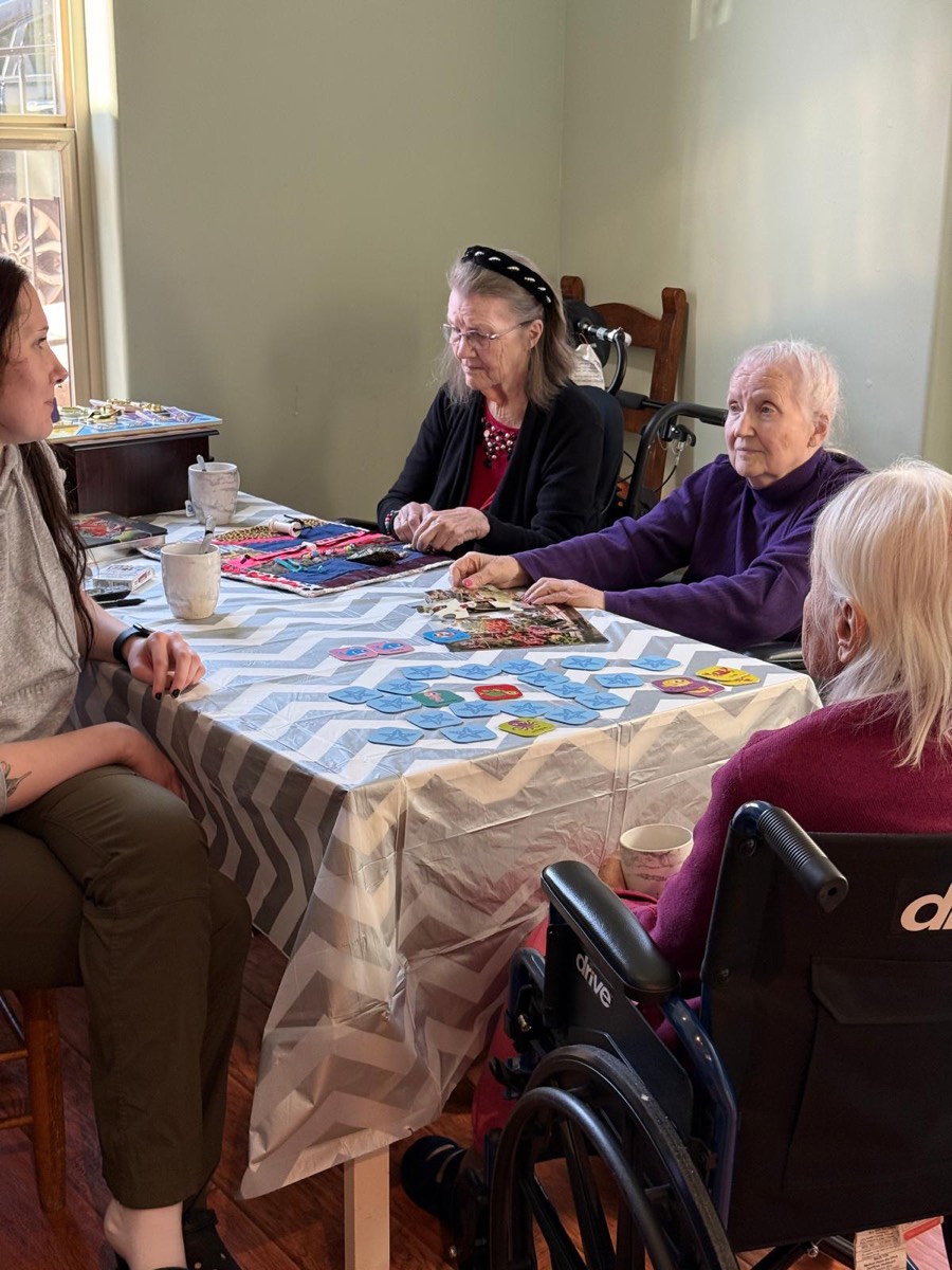 A caregiver helping residents with a craft project