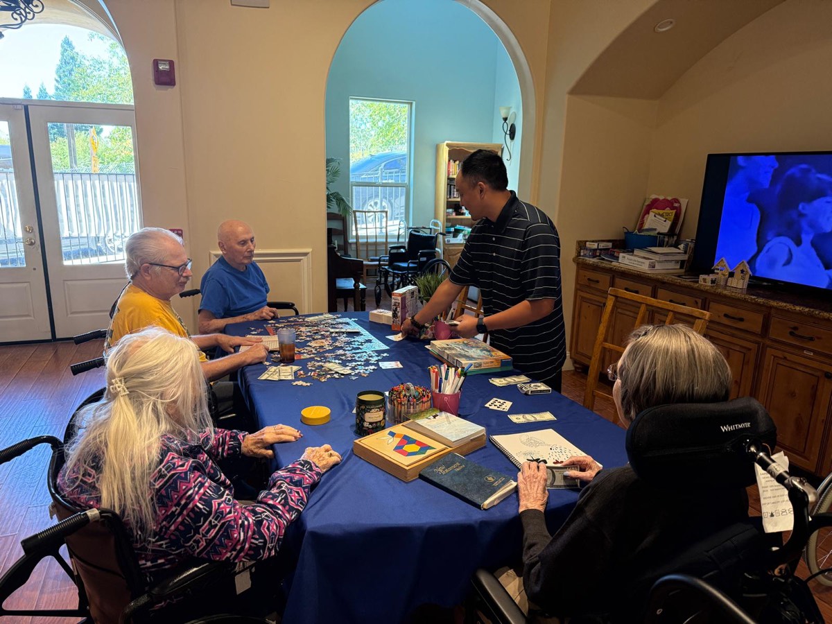 Residents and a caregiver at an activity table